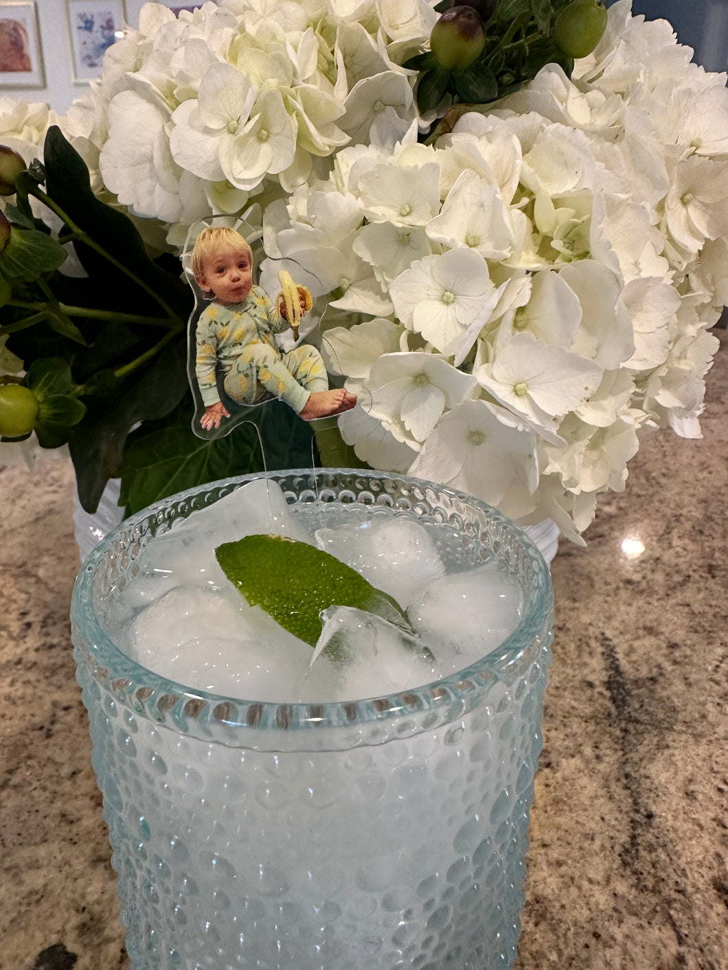 acrylic drink stir of baby holding banana in glass cup